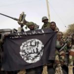Des soldats nigérians tiennent un drapeau de Boko Haram à Damasak, Nigeria, le 18 mars 2015